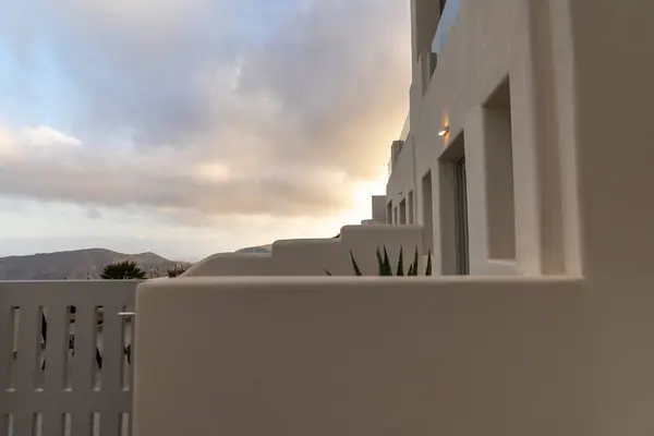 Santorini Yunanistan 'da beyazlatılmış binaların panoramik manzarasının keyfini çıkarın. Seyahat ve mimari aşıklar için çarpıcı bir gökyüzüne karşı modern tasarımlarla birleşerek benzersiz bir uyum vizyonunu vurgulayın.