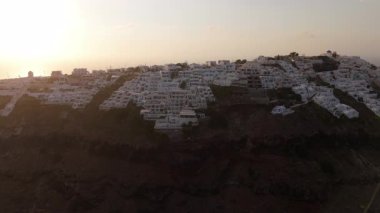 Hava manzarası, günbatımında parlayan, Santorini uçurumundaki çarpıcı, bembeyaz mimariyi ön plana çıkarıyor. Akdeniz manzarası, duyguları cezbediyor ve hayranlık uyandırıyor.