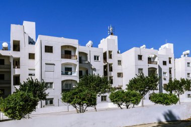 Güneşli bir günde, güneydeki beyaz evler mavi gökyüzüne karşı..