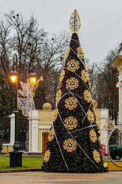 Parkın Noel süsü, oyuncaklarla süslenmiş Noel ağacı, ışıldayan geyik heykelcikleri..