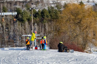 Ukrayna Kharkov 12.26.2021 Kış tatili bir kayak merkezinde kayak yapan ve snowboard yapan insanlar kış sporlarının ve temiz havanın keyfini çıkarıyorlar..