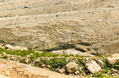 Güneşli bir günde buzulun yakın çekimi buzun kalınlığı küçük taşlarla kaplıdır..