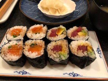 Geleneksel Japon Tabağı 'nda servis edilen ton balığı, somon, avokado ve soya soslu suşi ruloları..