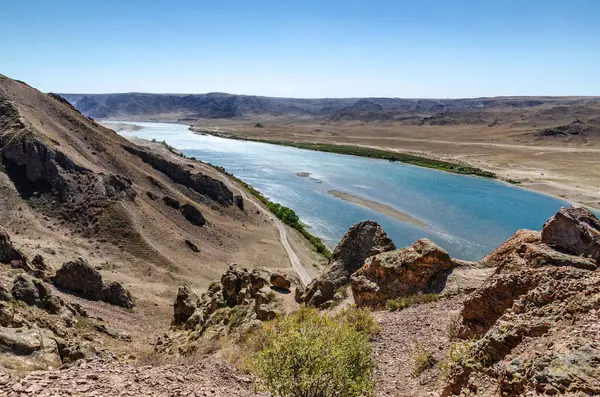 Dağ Nehri, Arid Kanyon Vadisi boyunca Rocky yamaçları ve berrak mavi sularıyla akıyor..