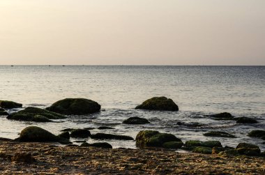İçlerinde açık denizle akan kayaların olduğu deniz kıyısı..
