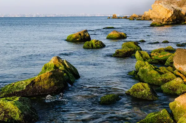 İçlerinde açık denizle akan kayaların olduğu deniz kıyısı..
