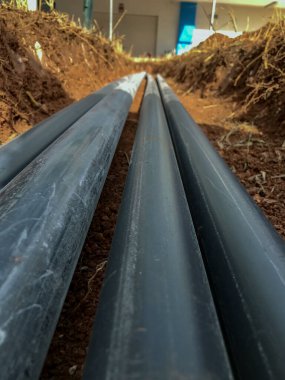pvc pipes laid in parallel inside a trench in the ground