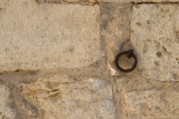 rusty metal ring anchored to a stone wall