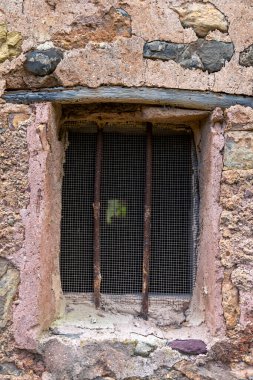 Ağlı ekranlı bir pencere. Pencere taştan bir duvarda.