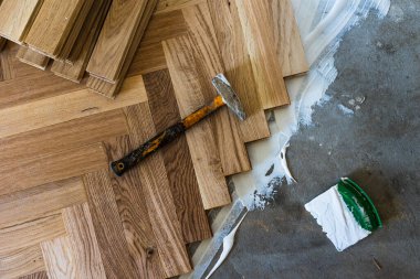 Top view of parquet boards installing in herringbone arrangement on glue, home flooring concept