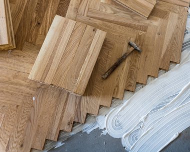 Top view of parquet boards installing in herringbone arrangement on glue, home flooring concept