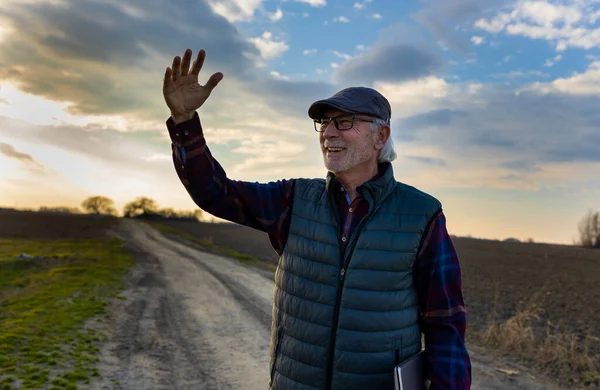 Senior Farmář Drží Notebook Chodí Prašné Cestě Pozdravuje Někoho Dálce — Stock fotografie
