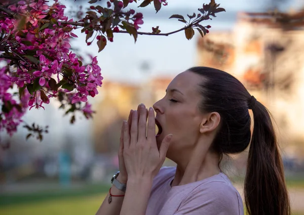 春に花粉を咲かせ くしゃみをするアレルギー症状のある若い女性 — ストック写真