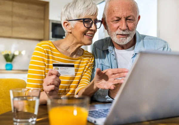 Fröhliches Seniorenpaar Sitzt Esstisch Mit Küche Hintergrund Und Kauft Online — Stockfoto