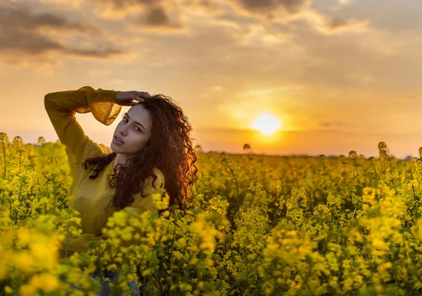 Hübsche Junge Frau Mit Lockigem Haar Blühenden Rapsfeld Bei Sonnenuntergang — Stockfoto