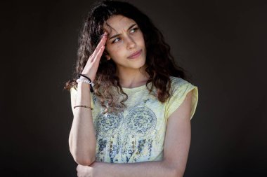 Stüdyoda el ele tutuşup yan gözle bakan genç ve düşünceli bir kız.