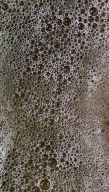 Balon şeklinde beyaz köpüğün soyut görüntüsü. Deniz suyu kumsalda köpük yapıyor.