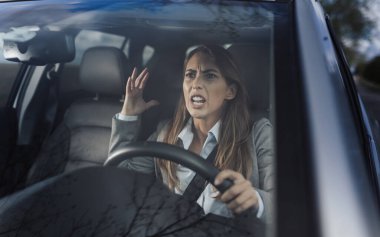 Araba süren ve trafikte diğer sürücülere bağıran iş kadını.