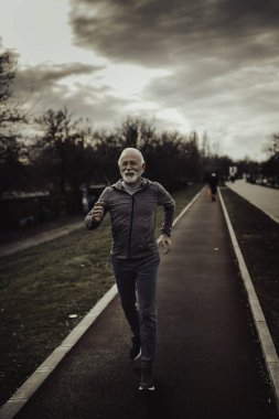 Son sınıf öğrencisi dışarıda koşu yapıyor. Spor, egzersiz ve sağlıklı yaşam tarzı konsepti