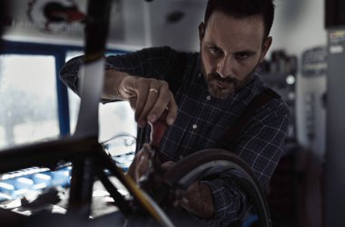 Atölyede bisiklet tamircisi olarak çalışan yakışıklı bir tamirci.