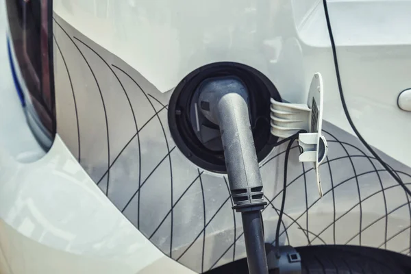 電気自動車充電は電気自動車に接続します 現代の技術で電気自動車のEv車に電力を充電する電源ケーブルポンププラグ ロイヤリティフリーのストック画像