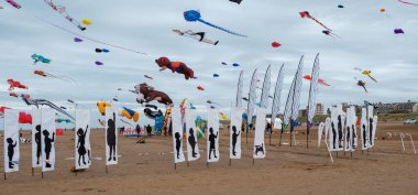 St Annes, Lancashire / Birleşik Krallık - 14 Eylül 2024: St Annes Kite Festivali. Sahile gidenler olarak gökyüzünü renkli uçurtmalar dolduruyor. Deniz kenarındaki yıllık uçurtma festivalinin tadını çıkarıyorlar.