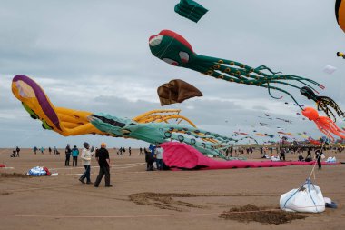 St Annes, Lancashire / Birleşik Krallık - 14 Eylül 2024: St Annes Kite Festivali. Canlı renkli uçurtmalar sahile gidenler deniz kenarında keyifli bir günün tadını çıkarırken gökyüzünü dolduruyor..