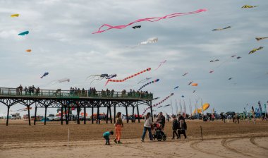 St Annes, Lancashire / Birleşik Krallık - 14 Eylül 2024: St Annes Kite Festivali. Canlı renkli uçurtmalar sahile gidenler deniz kenarında keyifli bir günün tadını çıkarırken gökyüzünü dolduruyor..