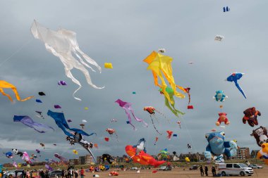 St Annes, Lancashire / Birleşik Krallık - 14 Eylül 2024: St Annes Kite Festivali. Canlı renkli uçurtmalar sahile gidenler deniz kenarında keyifli bir günün tadını çıkarırken gökyüzünü dolduruyor..