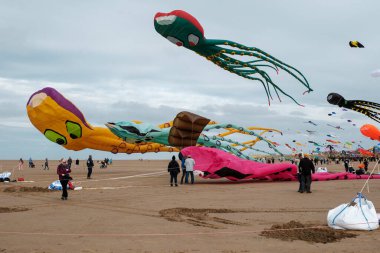 St Annes, Lancashire / Birleşik Krallık - 14 Eylül 2024: St Annes Kite Festivali. Canlı renkli uçurtmalar sahile gidenler deniz kenarında keyifli bir günün tadını çıkarırken gökyüzünü dolduruyor..