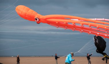 St Annes, Lancashire / Birleşik Krallık - 14 Eylül 2024: St Annes Kite Festivali. Canlı renkli uçurtmalar sahile gidenler deniz kenarında keyifli bir günün tadını çıkarırken gökyüzünü dolduruyor..