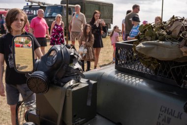 Lytham, Lancashire, Birleşik Krallık - 16 Ağustos 2025: Lytham Savaş Haftası ziyaretçileri tarihi askeri gösterilerine çeker. İnsanlar sergilere bakarken araçta antika bir gaz maskesi görülür..