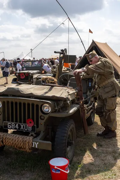 Lytham, Lancashire, Birleşik Krallık - 16 Ağustos 2025: Lytham Savaş Zamanı Hafta sonu 2. Dünya Savaşı 'ndan kalma Amerikan askeri üniformalı bir aktör popüler tarihi olay sırasında antika bir cipin yanında duruyor..