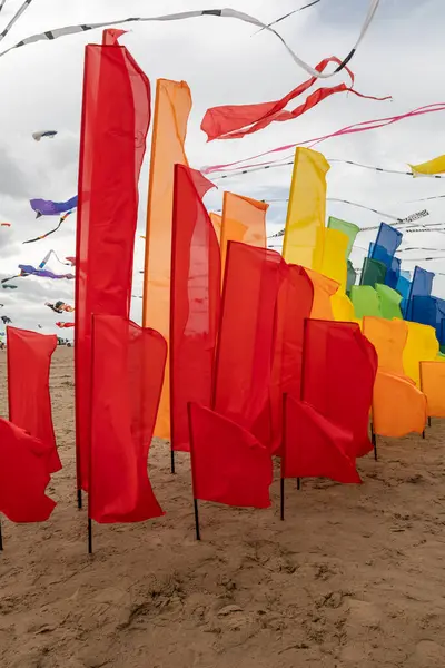 Vibrant flags in a spectrum of colors symbolize progress, celebration, and achievement against a bright sky.