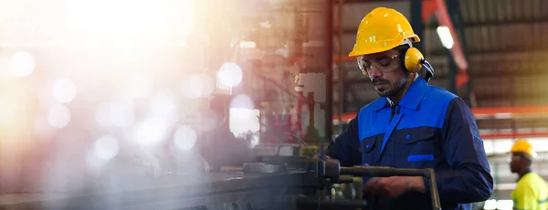 专业的工业工程师 工厂工人都戴着安全帽 安全眼镜 在检查 控制机器重工业工厂时 在制造厂工作的雇员 免版税图库图片
