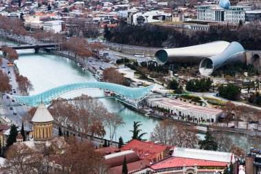 TBILISI, GEORGIA - 08 Ocak 2023: Tiflis Georgia 'nın güzel manzarası. Tiflis 'in ünlü simgesi Kura Nehri üzerindeki barış köprüsünü gezmek..