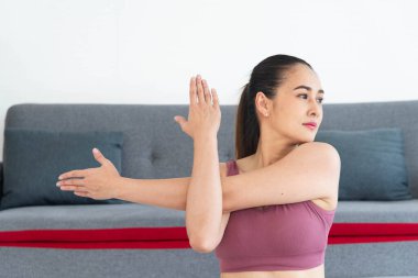 Spor yazılımlı Asyalı genç bir kadın evde yoga yapıyor, sporcu kız evde meditasyon yapıyor.