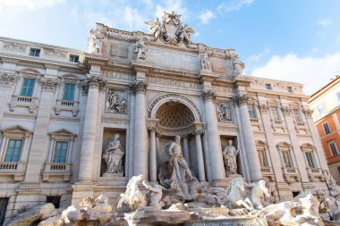Roma, İtalya-17 Nisan 2024: Roma 'daki Trevi Çeşmesi' nin çarpıcı manzarası, muhteşem mimari ayrıntılarını ve muhteşem heykellerini sergiliyor. Barok başyapıtı, parlak mavi bir gökyüzünün altında dünyanın dört bir yanından gelen ziyaretçileri cezbediyor..