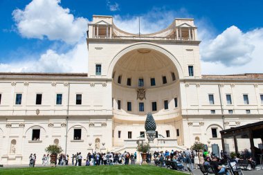 Vatikan, İtalya-18 Nisan 2024: Vatikan Müzelerinin Pinecone Avlusunun keyfini süren ziyaretçiler, güneşli bir günde ikonik kozalak heykeli ve çarpıcı bir mimariye sahipler..