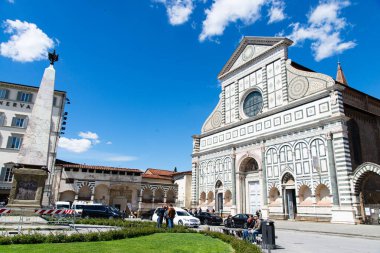 Floransa, İtalya-19 Nisan 2024: İtalya 'nın Floransa kentinde Santa Maria Novella' nın gösterişli cephesi, ziyaretçilerin ön planda güneşli bir günün keyfini çıkardıkları.