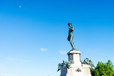 Floransa, İtalya-19 Nisan 2024: Floransa, İtalya 'daki Piazzale Michelangelo' da Davut 'un bronz heykeli, açık mavi bir gökyüzü ve arka planda ay.