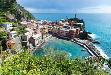 Cinque Terre 'deki Vernazza limanının çarpıcı hava manzarası, renkli binalar, pitoresk bir rıhtım ve turkuaz Akdeniz.