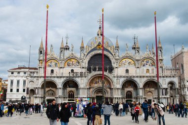 Venedik, İtalya-24 Nisan 2024: Venedik, İtalya 'daki tarihi St. Mark Bazilikası önünde turist kalabalığı, süslü mimarisi ve canlı mozaiklerini sergiliyor.