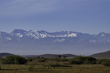 A beautiful view of the majestic Atlas mountains, from the Agafay Desert, on the outskirts of Marrakech, Morocco. There is snow on the mountains. clipart