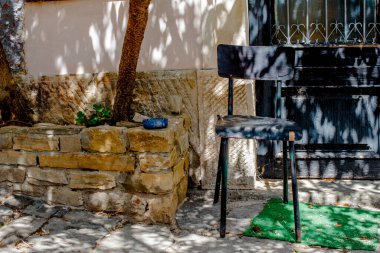 Hırvatistan 'ın küçük bir kasabasında sarmaşığın gölgesinde şarap kadehi ve küllükle boş bir sandalye