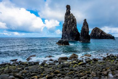 Atlantik Okyanusu bulutlu bir günde Madeira 'nın kayalıklarına ve kıyılarına çarpar. Madeira' nın kuzey kıyısında Seixal Madeira Portekiz yakınlarında sakin deniz ve gri bulutlar vardır.