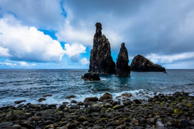 Atlantik Okyanusu bulutlu bir günde Madeira 'nın kayalıklarına ve kıyılarına çarpar. Madeira' nın kuzey kıyısında Seixal Madeira Portekiz yakınlarında sakin deniz ve gri bulutlar vardır.