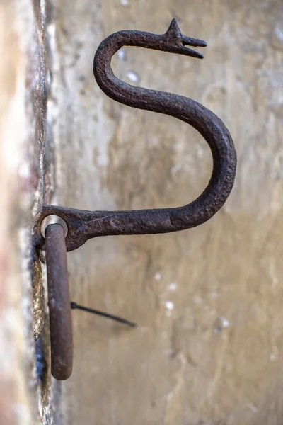 stock image ancient hook for tying horses in the shape of a snake comes out of the wall of a medieval house in Bologna