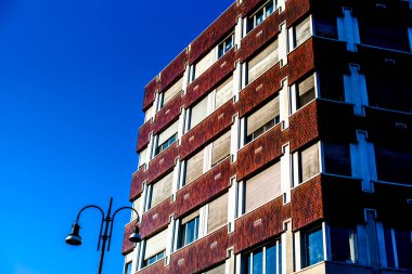 Mavi gökyüzünde tuğlaları ve beyaz pencereleri olan mimari gökdelen binası