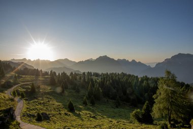 Belluno Alpleri 'nin zirveleri arasında gün doğarken Gossaldo Belluno Veneneto İtalya' daki Belluno Dolomitleri 'nde otlayan çayırlarla gün doğuyor.